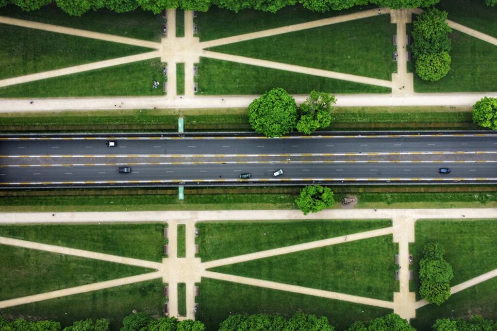 overhead photo of road and green landscape surrounding